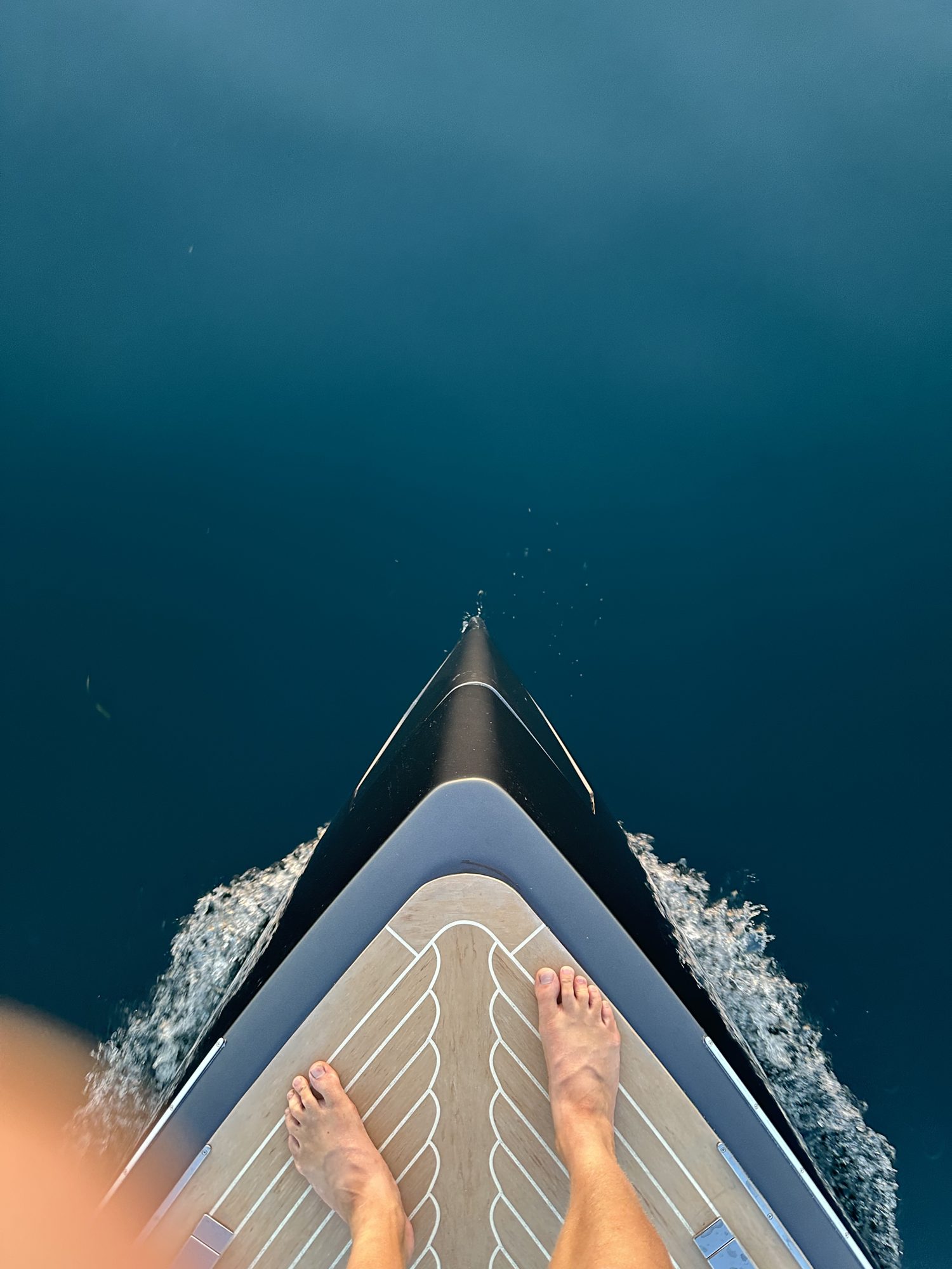 The bow of the boat cutting through deep blue water